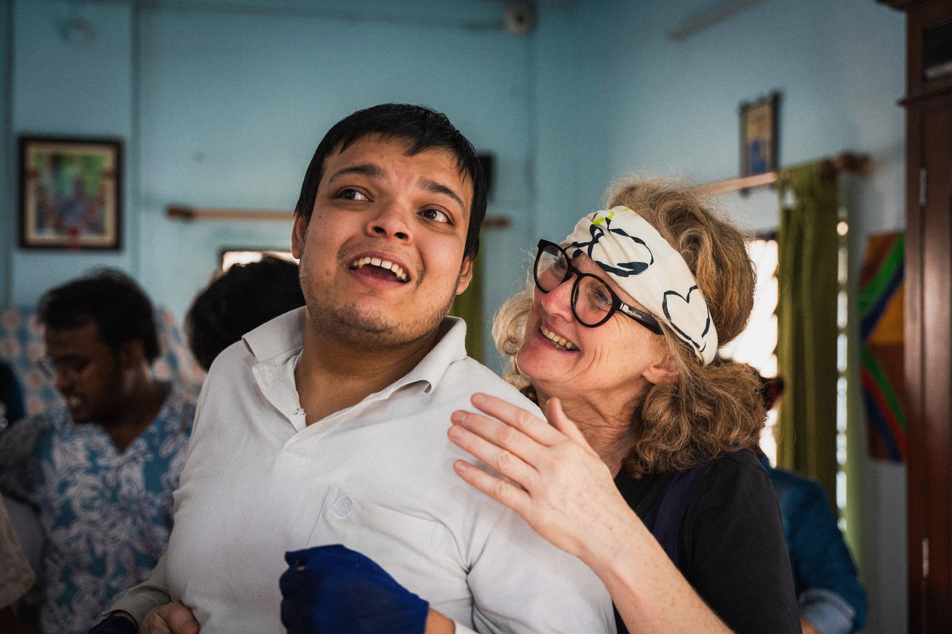 Two performers share a joyful moment during a Shakespeare workshop in India, capturing connection, support, and creativity while working with autistic artists.
